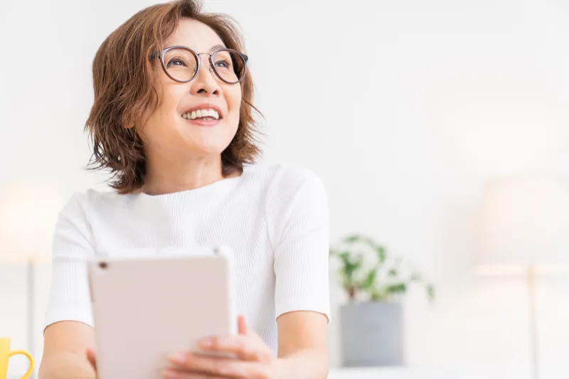 タブレットを持って微笑む女性